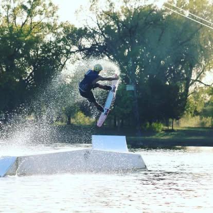 Wakeboarder launching off a kicker ramp at Wake Zone